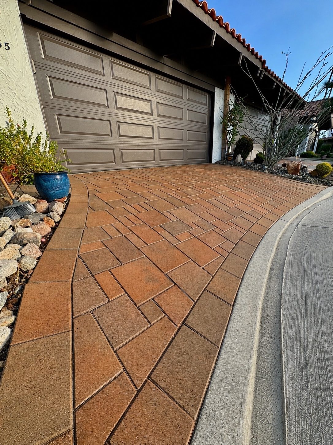 Same driveway after pressure washing — pavers restored to bright warm tones, looking like new